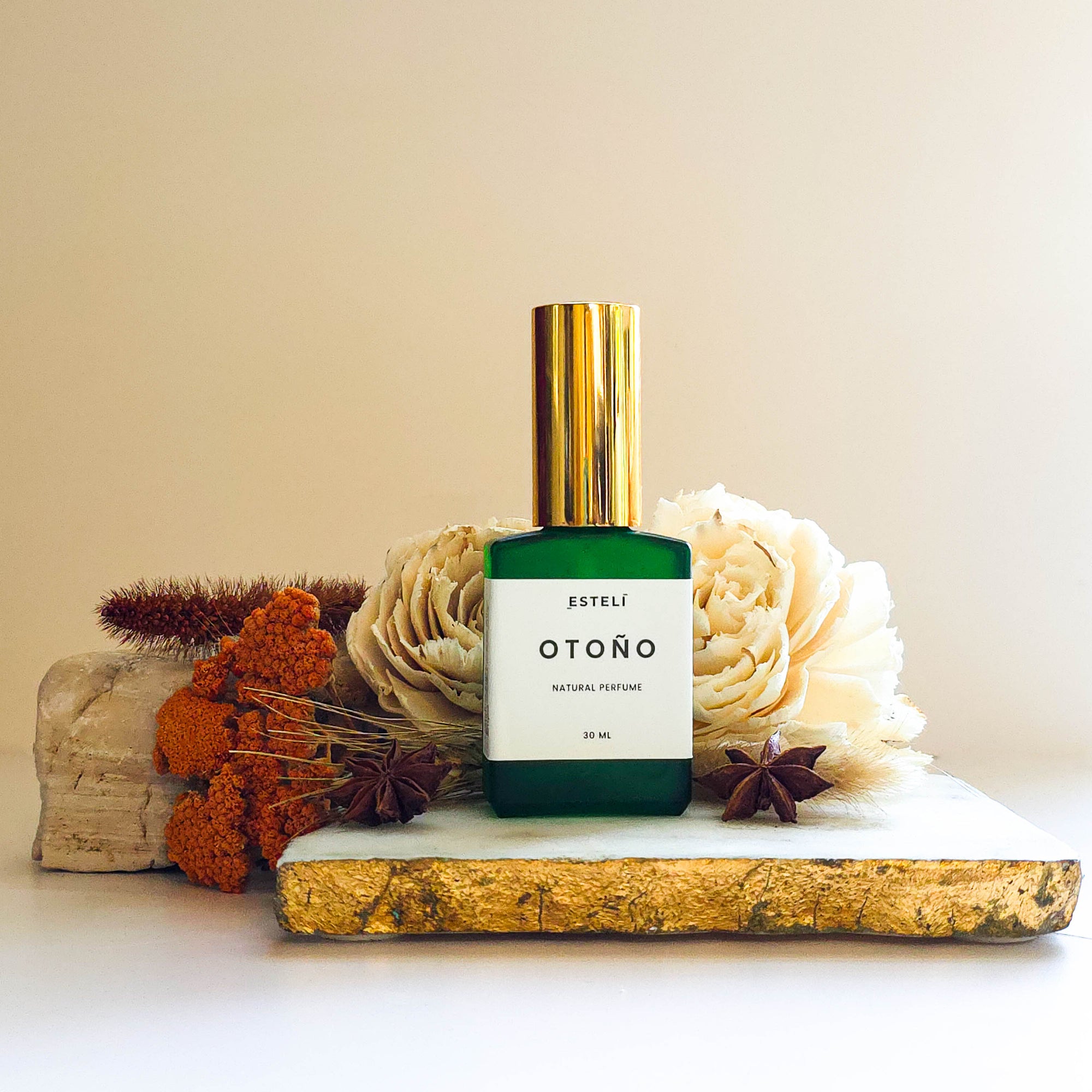 Otoño Perfume Botanicá by Estelí on a decorative surface with flowers and natural elements.