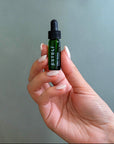 Hand holding ESTELÍ Oro Rosa Supercriticals Face Oil mini