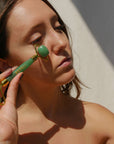 Woman using Esteli Green Aventurine Facial Roller