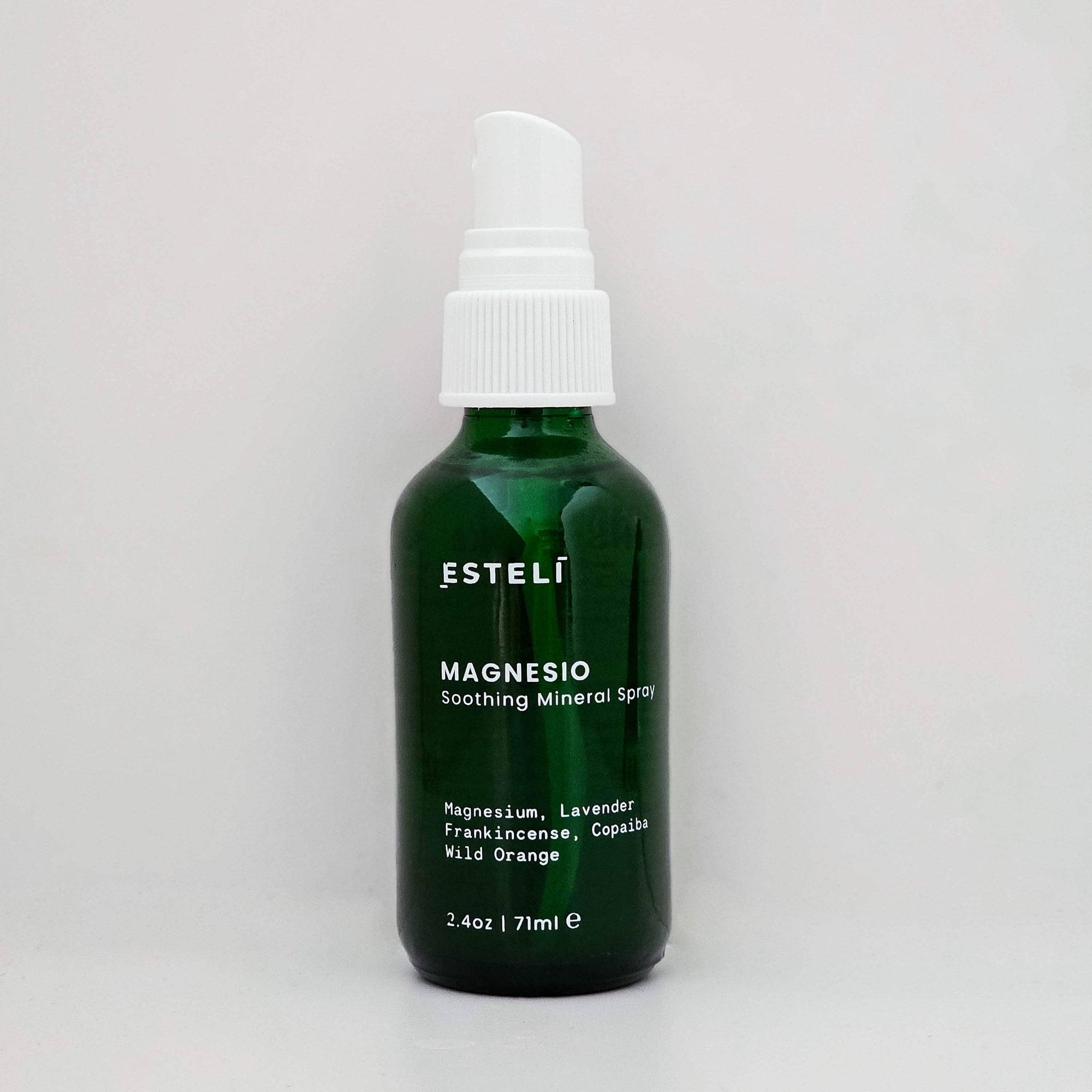 Green bottle of Esteló Magnesio Soothing Mineral Spray on a light gray background