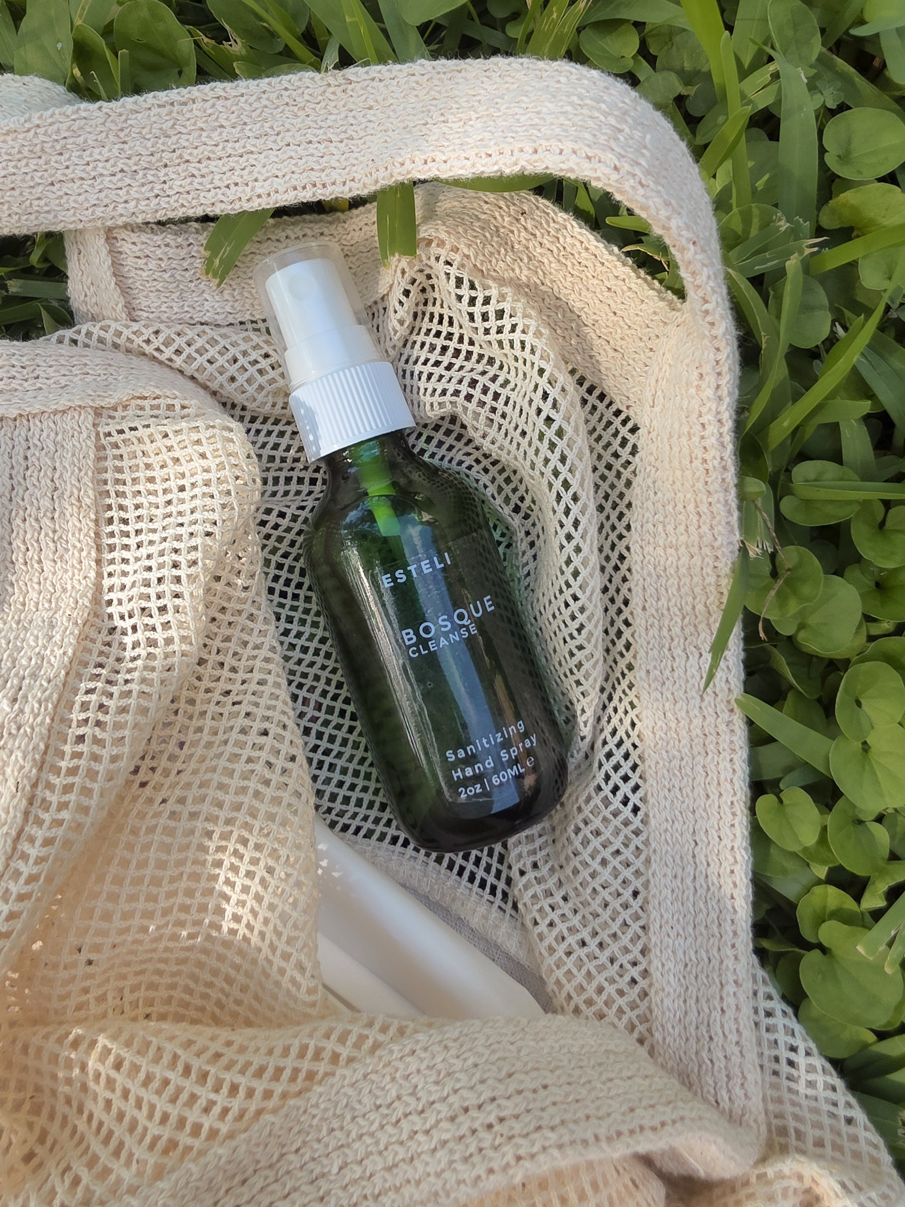 Bosque botanical hand spray tucked into a cream mesh tote with diaper wipes