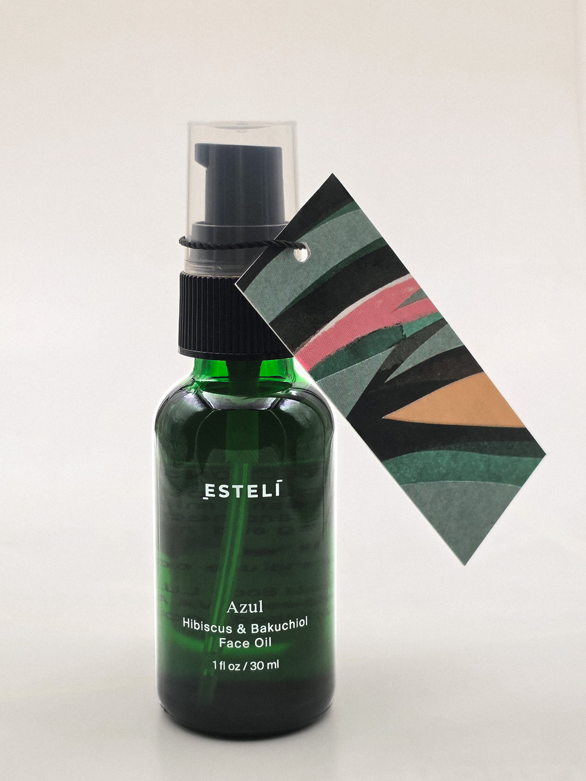 ESTELÍ Azul Hibiscus &amp; Bakuchiol Face Oil in a 30 ml green glass pump bottle with a colorful abstract artwork tag.