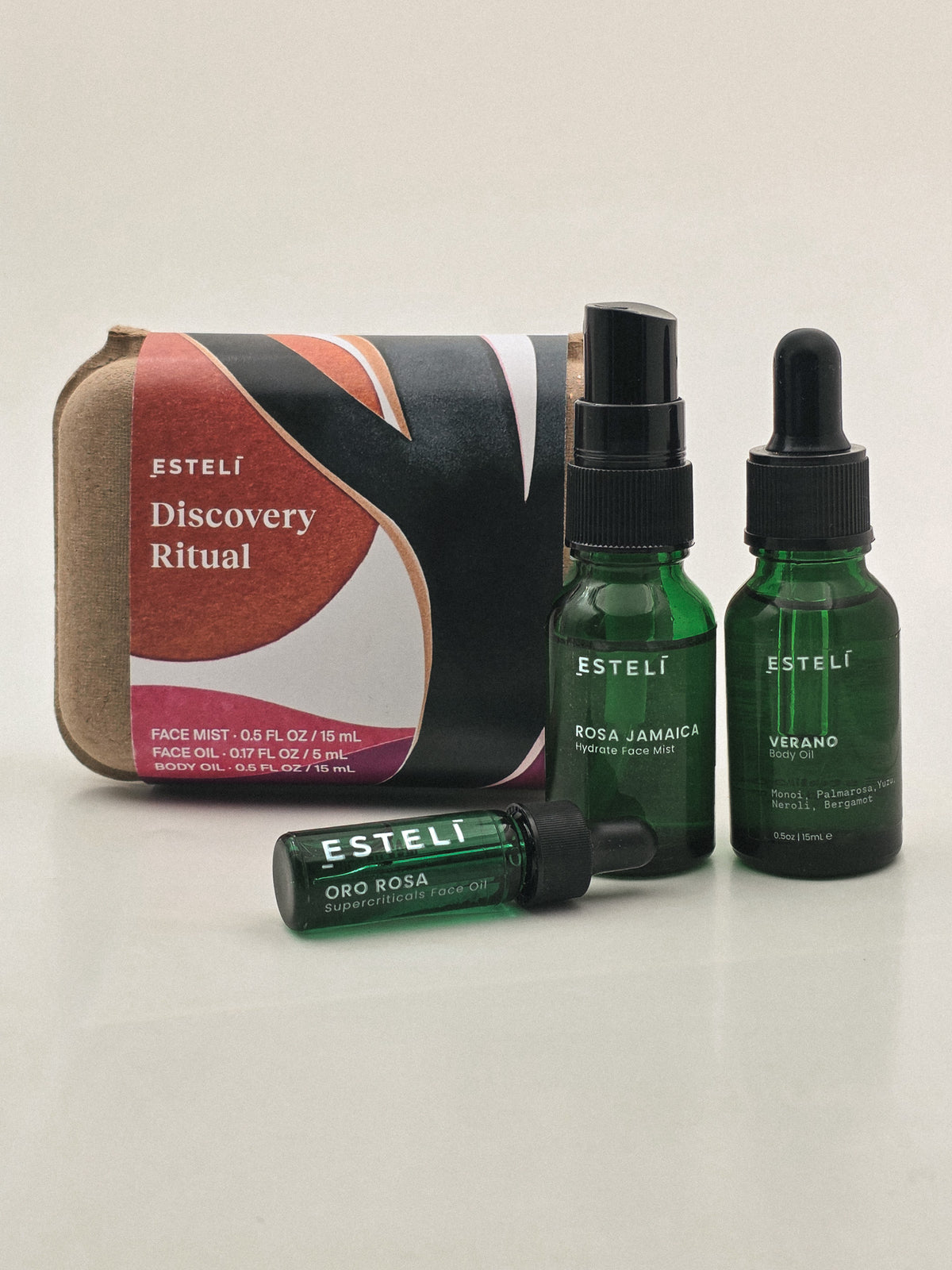 ESTELÍ Discovery Ritual with Rosa Jamaica mist, Oro Rosa face oil, Verano body oil, and illustrated packaging.