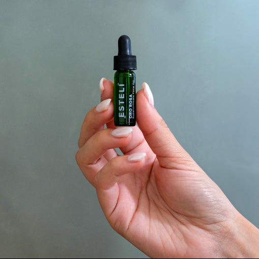 Hand holding ESTELÍ Oro Rosa Supercriticals Face Oil mini