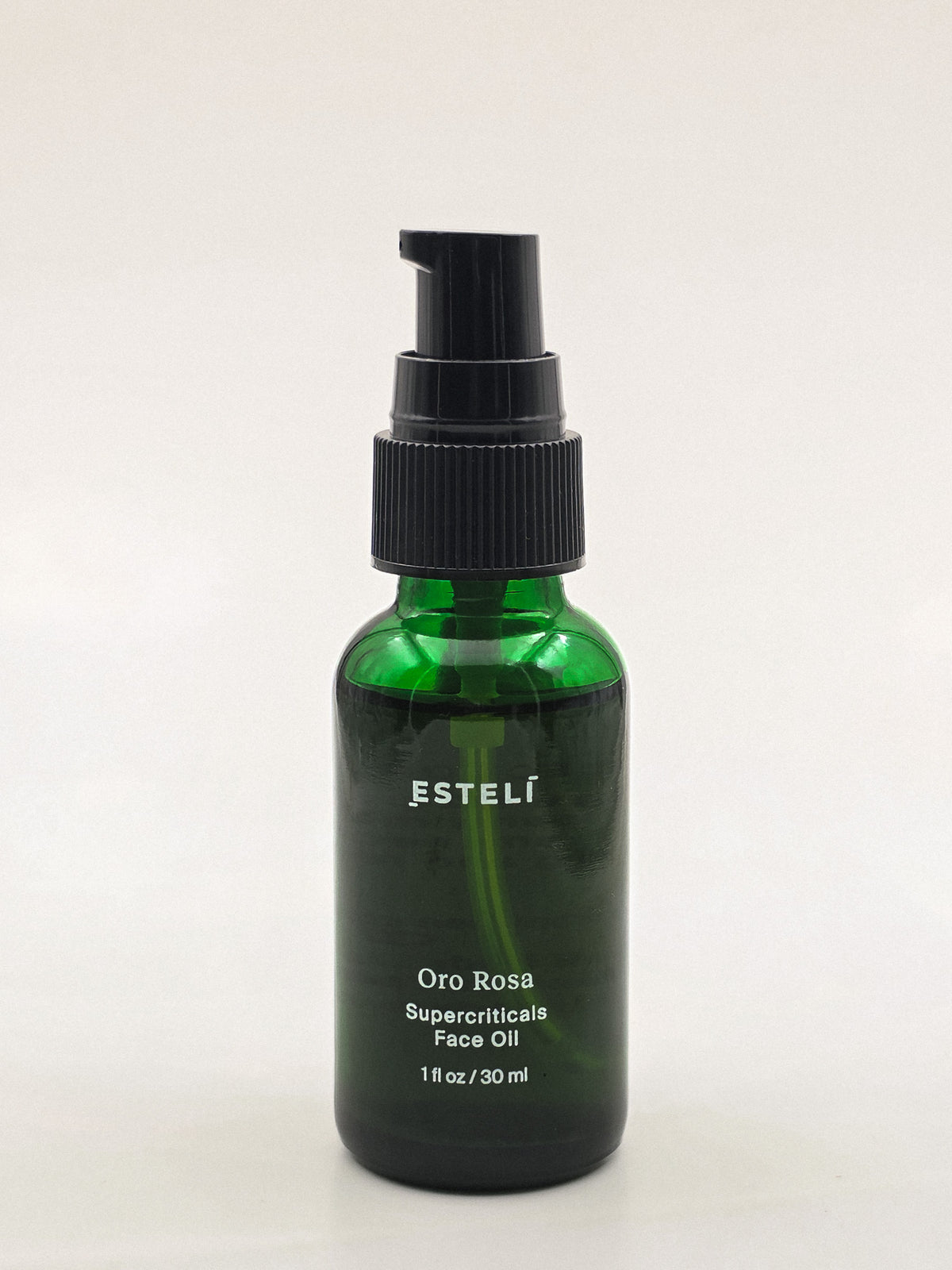 ESTELÍ Oro Rosa Supercriticals Face Oil in a green 30 ml bottle with the cap removed to show the black pump.