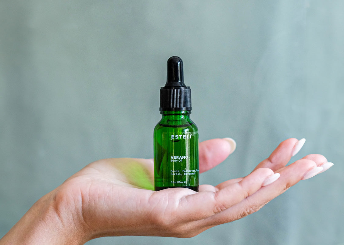 ESTELÍ Verano Body Oil mini resting in an open hand