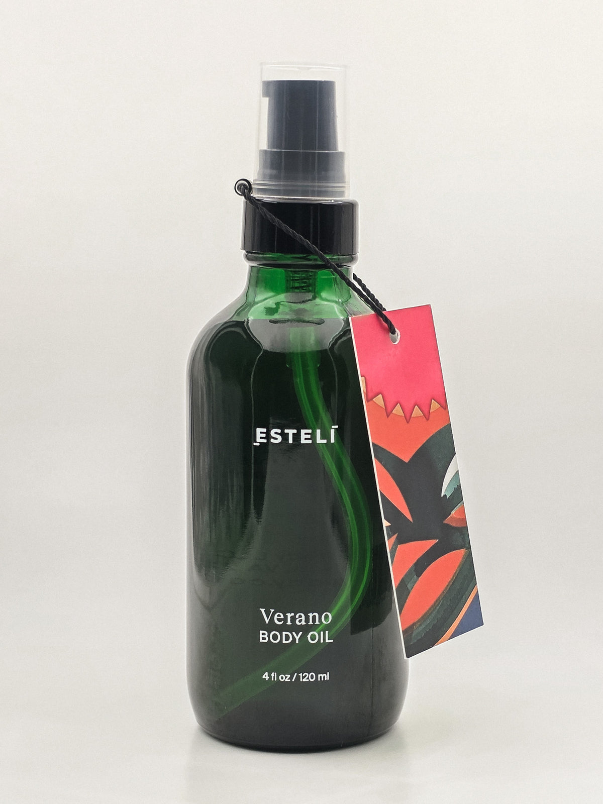 ESTELÍ Verano Body Oil in a green glass pump bottle with a colorful illustrated hang tag, 4 fl oz / 120 ml