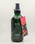 ESTELÍ Verano Body Oil in a green glass pump bottle with a colorful illustrated hang tag, 4 fl oz / 120 ml