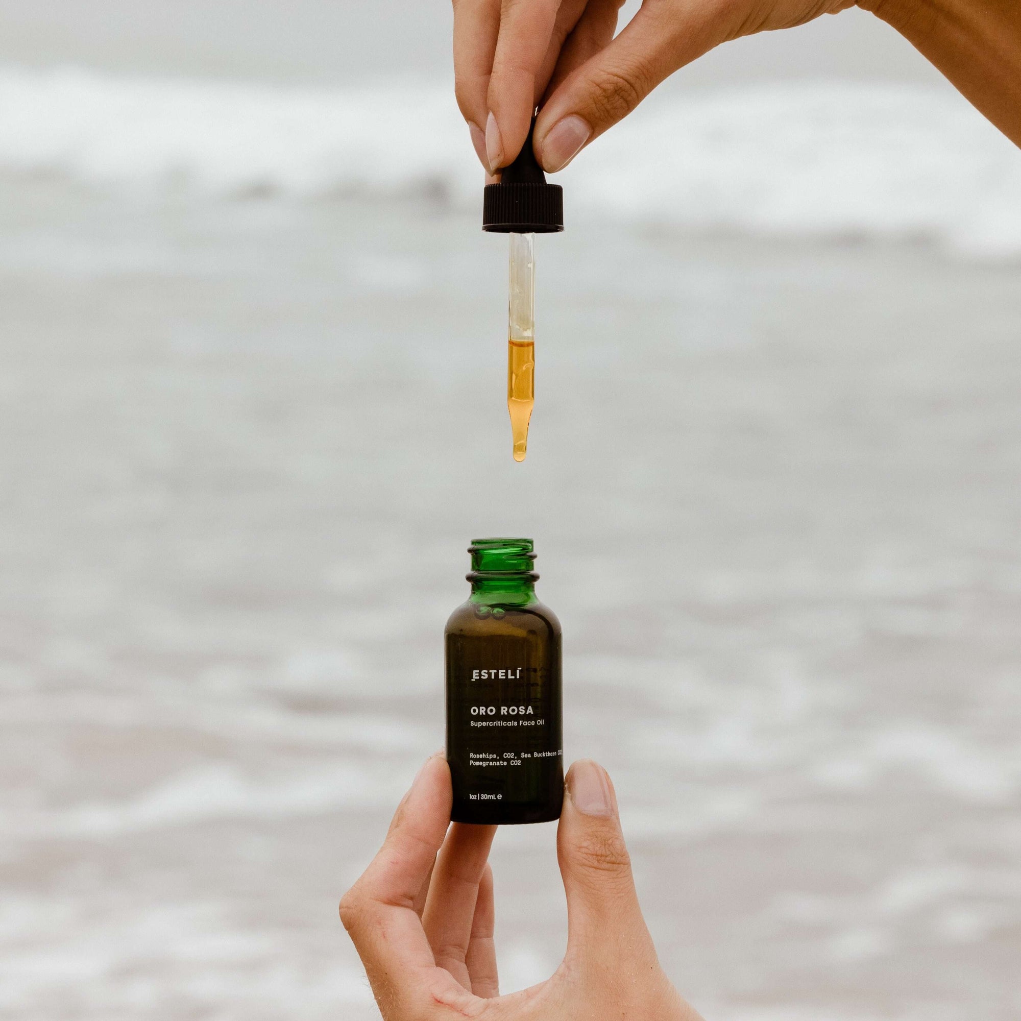 Golden botanical face oil dropper showing Oro Rosa’s silky texture