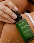ESTELÍ Rosa Jamaica Hydrating Face Mist held near sun-warmed skin